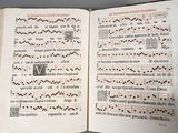 an open book with a cross stitch pattern on it