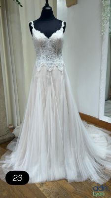 une robe de mariée posée sur un mannequin devant un miroir