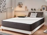 une photo d'une chambre à coucher avec un lit blanc et un tapis noir et blanc