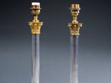a pair of brass and glass table lamps with candles on them