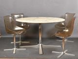 trois chaises disposées autour d'une table au plateau en marbre