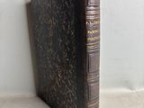 an old book sitting on top of a table next to a white wall
