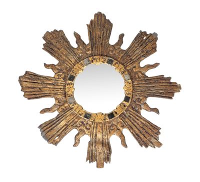 une image représentant un miroir doré en forme de soleil rayonnant sur fond blanc