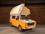 a small van with a tent on top of it in a garage