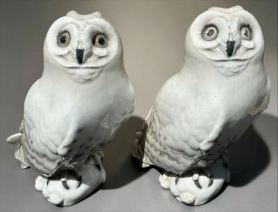 two white owl figurines sitting on top of each other