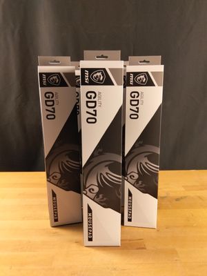 three black and white boxes on a wooden table with a black background