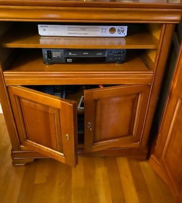 a television sitting on top of a wooden cabinet