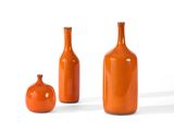 three orange vases sitting next to each other on a white surface