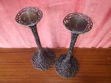 two metal candlesticks sitting on a wooden table