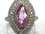 an image of a pink and white diamond ring sitting on top of a clear stand
