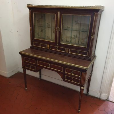 une armoire en bois surmontée de portes vitrées