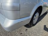 the rear end of a silver van parked on the side of the road