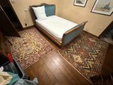 a bedroom with a bed and a rug on the floor