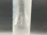 a glass of water sitting on a table next to a bottle
