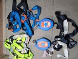 several pairs of shoes and a backpack are on the ground