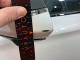 a person holding a ruler in front of a car