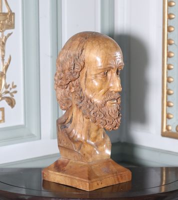 une statue représentant un homme barbu assis sur une table