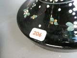un vase noir orné de fleurs, posé sur une table