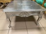 une table basse argentée posée sur un sol carrelé dans un salon