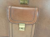 a brown leather bag with a gold lock on it
