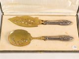 two silver spoons in a box on a white surface