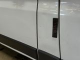 a close up of a door handle on a white truck