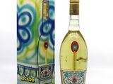 des bouteilles d'alcool posées à côté d'une boîte sur une surface blanche