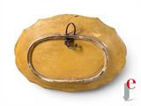 a yellow bowl with a metal handle on a white surface