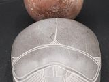 an image of a stone object with a ball on top of it