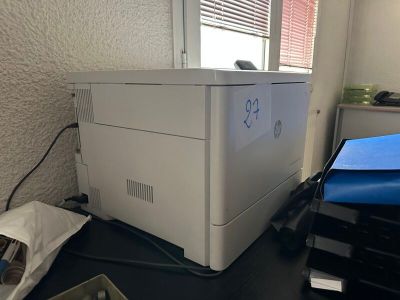 une imprimante blanche posée sur un bureau près d'une fenêtre