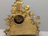 an image of a gold clock sitting on top of a white table