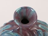 a blue and purple vase sitting on a white surface