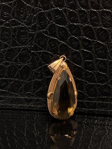 Pendentif en forme de poire à décor d’un quartz en métal doré. Fr