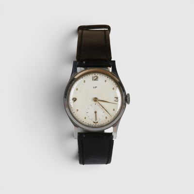 un gros plan d'une montre sur une surface blanche avec un fond blanc