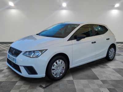 Une voiture blanche est garée sur un sol en carrelage à damier.