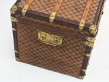 a brown and tan checkered suitcase sitting on a white surface