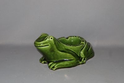 une petite figurine de grenouille verte posée sur une table