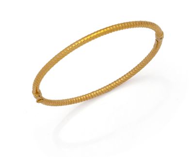a close up of a gold bracelet on a white background