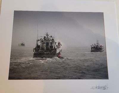 a picture of a boat in the water with other boats in the background