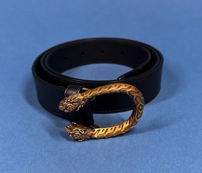 a close up of a black belt with a gold buckle on it
