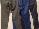 three pairs of men ' s pants hanging on a clothes rack