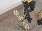 a black and gold statue on the floor next to a lamp