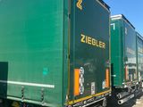 a green truck that is parked next to another truck