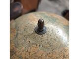 a close up of an old globe with a wooden handle