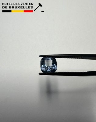 a close up of a pair of pliers holding a blue diamond