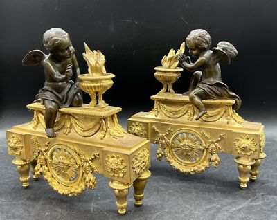paire de figurines anciennes en bronze représentant des chérubins, posées sur une table