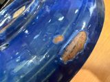 a close up of a blue vase on a table