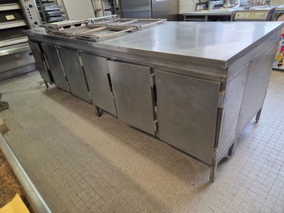 a large stainless steel kitchen island in the middle of a kitchen