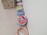 many rolls of yarn on the floor next to a refrigerator