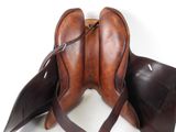 brown leather saddle with two straps on a white background